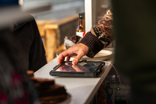 Food and beverage van worker serving customer taking order on tablet device