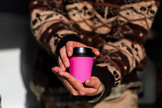Cup of coffee in disposable paper cup held by barista in coffee van