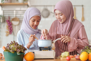 muslim girl with mother in hijab cooking organic vegetables and fruits together in the kitchen