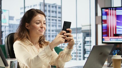 Fototapeta premium Powerful woman director receives project updates via text messages, discussing with the employees on the online corporation network. Female leader CEO with strategic thinking. Camera B.