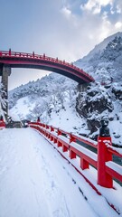 Snowy red bridge arching over valley
