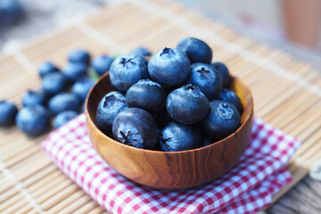 Blueberries in wood bowl on wooden table