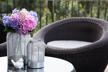 Multicolored hydrangeas in the interior of a cozy terrace or patio. A bouquet of garden plants. The concept of landscape design for a house.
