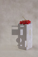 Still life with a bunch of red viburnum on a white brick