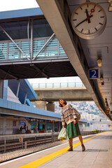 girl looking at watch and waiting for train. girl standing at train station waiting for train.