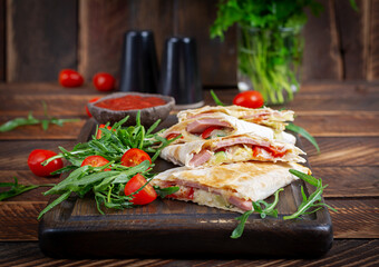 Traditional mexican quesadillas with sliced ham also called sincronizadas on wooden background. Overhead