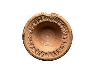 Top-down view of an ancient, terracotta bowl with floral edge, isolated on black