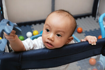 Cute little boy 11 months old playing on the mat with her toys, baby care, stock photo