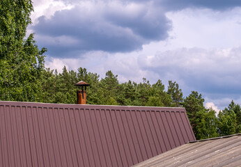 An iron round chimney on the roof of the house.