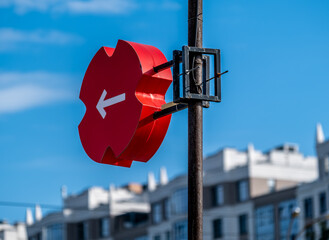 The arrow on the direction indicator on a pole in the city.
