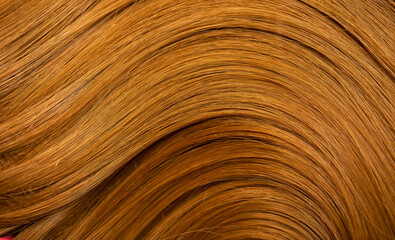 Red hair close-up as a background. Women's long orange hair. Beautifully styled wavy shiny curls. Hair coloring bright shades. Hairdressing procedures, extension.