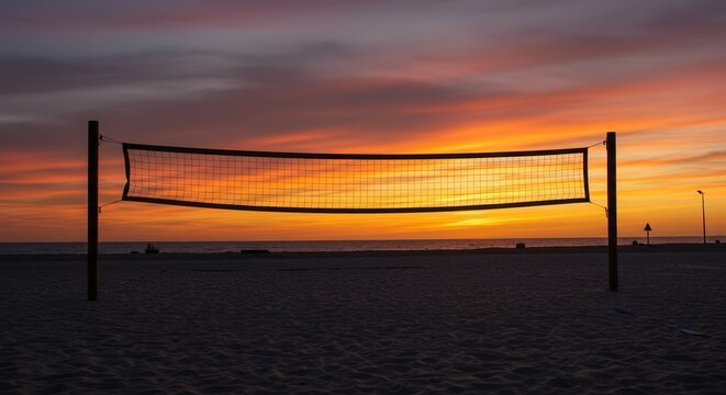 Empty sandy beach with volleyball court and stretched net, sunset dark sky and sea on background. Sports on vacation, activities, recreational holidays. Summer season. Tournaments and championships