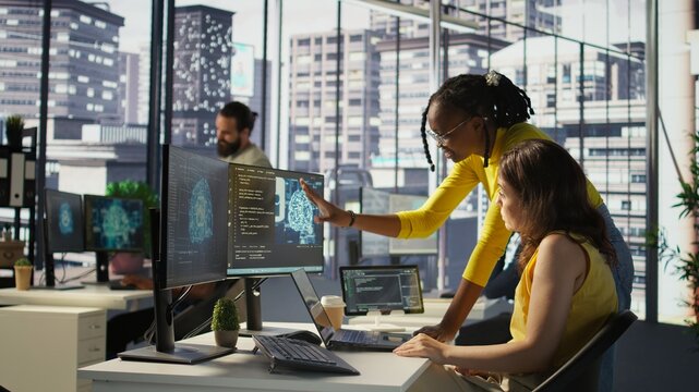 Admin and coworker conducting experiments and tests to optimize AI machine learning models for performance and accuracy. Team of IT experts in office analyzing artificial intelligence data, camera B