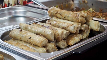 Fried spring rolls are in a metal container. Nem Ran. Vietnamese cuisine at the World Cuisine Festival. Side view. High-calorie food.