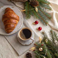 Christmas breakfast with coffee cup, croissant, and festive holiday decorations