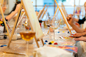 People painting on easels enjoying wine workshop