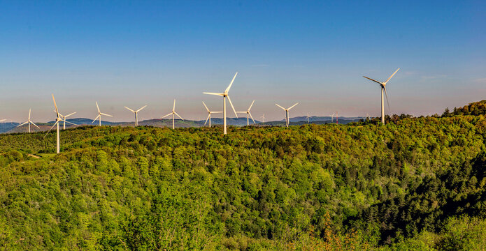 fields of wind turbines on the French hills in the herault on a blue sky background.