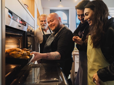 Friends enjoying a cooking class together laughing in a kitchen