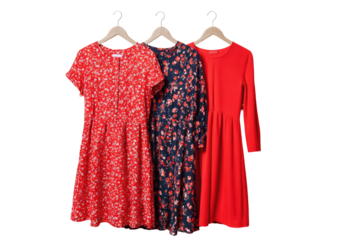 Three dresses of varying lengths & floral/solid patterns hang on wooden hangers
