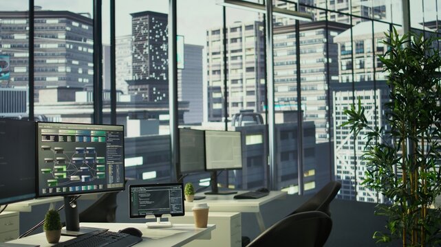 Programming language on digital devices screen in empty IT department office used for app development. Panning shot of tablet and PC left open on desk in tech startup company workspace with nobody in