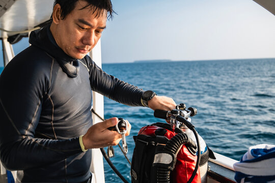 Diver checking his air pressure on pressure gauge in the Maldives