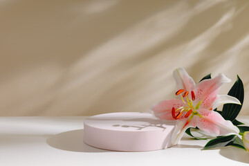 Aesthetic pink podium with pink lily flower on beige background with beautiful shadows. Elegant showcase for product presentation
