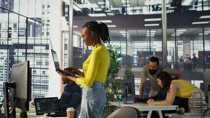 System administrator creating machine learning models that can process and analyze data to automate decision making processes. IT staff member using laptop to do programming in office, camera B