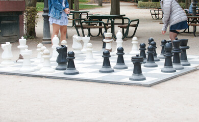 People playing chess outdoors with huge pieces