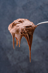 Cream chocolate in a spoon on a black background