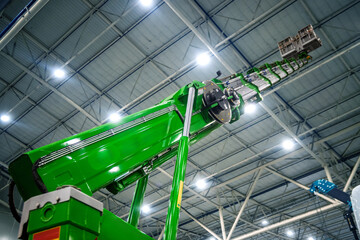 Modern bright green industrial machinery, a telescopic boom or crane, extending upwards in a...