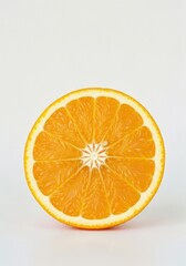 Close up of a vibrant orange slice with bright citrus segments and white pith on a clean white background with soft studio lighting