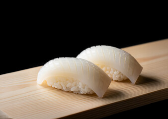 新鮮なイカ握り寿司：黒背景に際立つ、職人技が光る高級和食