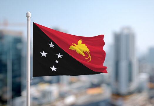 Waving the flag of Papua New Guinea in the blue sky. Papua New Guinea flag for Independence Day and National Day
