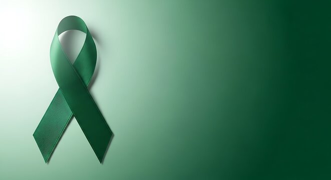 Pink ribbon breast cancer awareness symbol next to a fork and spoon on a green background