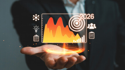 Businessman presents 2026 financial data and growth projections with holographic interface showcasing charts targets and team collaboration icons