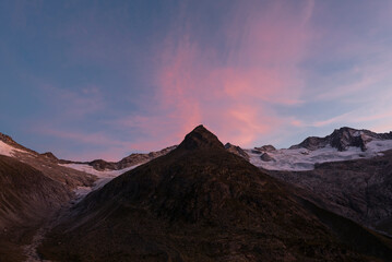 Das pyramidenförmige Steinmandl vor Geltschern, Berggipflen und den rötlichen Schleierwolken bei Sonnenuntergang an der Berliner Hütte, Zillertal, Tirol, Österreich