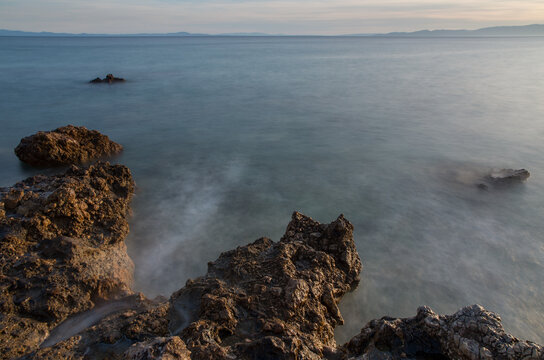 Long exposure of waves around the rocks at sunset, Mediterranean, Greece