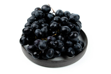 A bunch of black grapes on a white background. Fresh and juicy grapes.