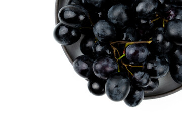 A bunch of black grapes on a white background. Fresh and juicy grapes.