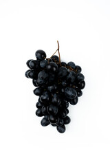 A bunch of black grapes on a white background. Fresh and juicy grapes.