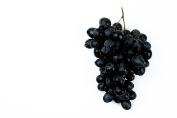 A bunch of black grapes on a white background. Fresh and juicy grapes.