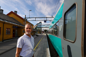 smiling man at the train station along the most scenical railway track between Oslo and Bergen