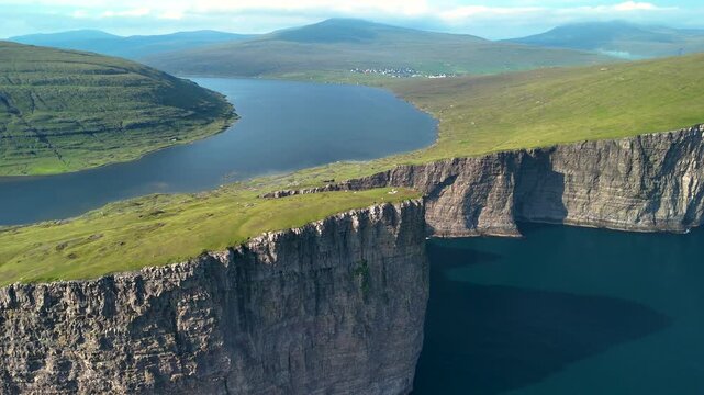 Discover the stunning landscape of Lake Sorvagsvatn, where cliffs meet serene waters in the Faroe Islands. Enjoy the lush greenery and dramatic views that define this unique location.