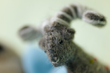 Detailed close-up of a soft, handmade sheep plush toy, highlighting its texture, craftsmanship, and cute design.