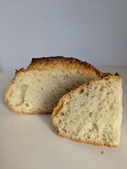 Fresh, homemade whole wheat bread sliced open on a white table. Represents healthy, wholesome eating and baking.