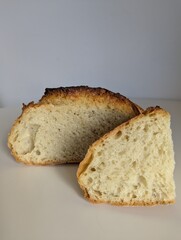 A rustic, artisanal loaf of bread cut open, revealing its airy crumb. Perfect for authentic, homemade food concepts.