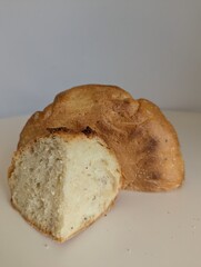 A single loaf of homemade bread, sliced in half, isolated on a white background. A simple, clean food photograph.