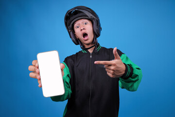 Male Online Delivery Driver With Helmet is Shocked Holding up Mobile Phone Mockup Against Blue...