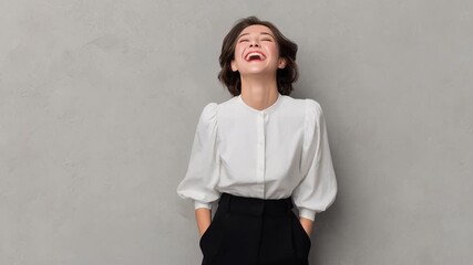 Young woman laughing in white blouse and black trousers joyful portrait casual neutral background with smile hands in pockets laughter studio portrait