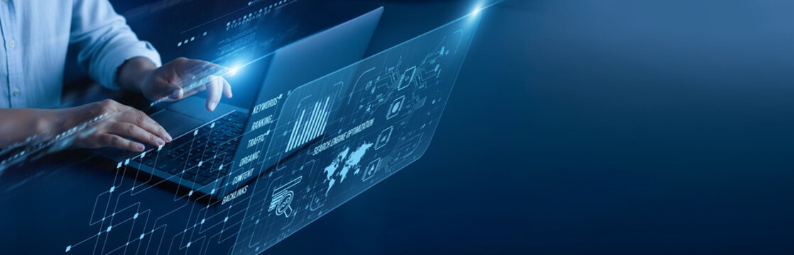 Search Engine Optimization network connection concept. Digital marketer hand working on a laptop computer with graphical keyword ranking analytics traffic performance visibility metrics. - Powered by Adobe